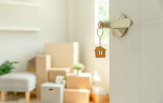 Choose the Right Property Management Company, open door, key in lock, boxes in brightly lit background
